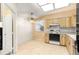 Bright kitchen with tile flooring, light wood cabinets and white appliances at 10833 Sw 86Th Ter, Ocala, FL 34481