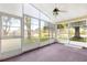 Enclosed porch featuring a ceiling fan and multiple windows offering bright natural light at 10833 Sw 86Th Ter, Ocala, FL 34481