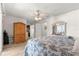 Bright bedroom features wood-look flooring, ceiling fan, and wardrobe for storage at 10989 Sw 86Th Ave, Ocala, FL 34481