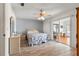Bright bedroom features wood-look flooring, ceiling fan, and sliding glass doors to the Florida room at 10989 Sw 86Th Ave, Ocala, FL 34481