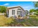Charming home exterior featuring a patio area, manicured landscaping, and a well-maintained lawn at 10989 Sw 86Th Ave, Ocala, FL 34481