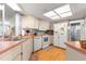 Bright kitchen featuring white appliances, wood floors, and ample counter space with a view of the bathroom at 10989 Sw 86Th Ave, Ocala, FL 34481