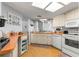 Bright kitchen featuring white appliances, wood floors, and ample counter space with a sink under the window at 10989 Sw 86Th Ave, Ocala, FL 34481