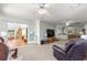 Open-concept living area featuring carpet floors, ceiling fan, and access to the lanai through sliding glass doors at 10989 Sw 86Th Ave, Ocala, FL 34481