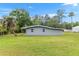 A spacious backyard featuring lush green grass and mature trees at 11065 Ne 42Nd St, Silver Springs, FL 34488