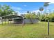 A metal open shed outside with view of a grey house and green grass at 11065 Ne 42Nd St, Silver Springs, FL 34488