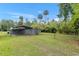 Open metal carport of a grey house with a large green lawn and many trees at 11065 Ne 42Nd St, Silver Springs, FL 34488