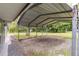 Close up of the metal carport with gravel, with green grass in the background at 11065 Ne 42Nd St, Silver Springs, FL 34488
