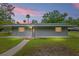 Single-story home showcasing a well-maintained lawn and serene sunset backdrop at 11065 Ne 42Nd St, Silver Springs, FL 34488