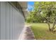 Side view of a grey home with green grass, a walkway and small trees at 11065 Ne 42Nd St, Silver Springs, FL 34488
