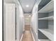 Hallway with grey walls, wood floors and open shelving at 11065 Ne 42Nd St, Silver Springs, FL 34488
