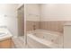 Bathroom featuring a large bathtub, shower, and tiled walls at 13645 Se 42 Ave, Summerfield, FL 34491