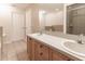 Bright bathroom featuring double sinks, a large mirror, and a tiled shower/tub combo at 13645 Se 42 Ave, Summerfield, FL 34491