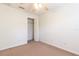 Carpeted bedroom with ceiling fan and closet with door open to view shelf and bar at 13645 Se 42 Ave, Summerfield, FL 34491