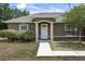 Inviting front entrance highlighting the home's architectural details, neat landscaping, and fresh exterior paint at 13645 Se 42 Ave, Summerfield, FL 34491