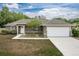 Attractive home showcasing a neatly paved driveway leading to an attached two-car garage, with a well-kept lawn and neutral exterior at 13645 Se 42 Ave, Summerfield, FL 34491