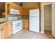 Well-lit kitchen featuring a refrigerator, oven, and ample cabinet space at 13645 Se 42 Ave, Summerfield, FL 34491