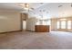 Expansive living room featuring a beamed ceiling, ample natural light, and neutral carpeting, perfect for entertaining at 13645 Se 42 Ave, Summerfield, FL 34491