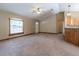 Bright living area showing large windows, a ceiling fan, and easy access to the front door and kitchen at 13645 Se 42 Ave, Summerfield, FL 34491