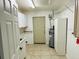 Well-lit laundry room with tile floors, washer/dryer hookups and cabinetry for storage at 15069 Se 73Rd Ave, Summerfield, FL 34491