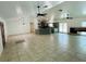 Open-concept living room with tile flooring, ceiling fans, and a view into the modern kitchen at 15069 Se 73Rd Ave, Summerfield, FL 34491