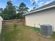 Cozy backyard with a wooden fence, green grass, and an air conditioning unit on the side of the house at 15976 Sw 23Rd Court Rd, Ocala, FL 34473