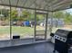 This screened porch is perfect for enjoying the outdoors, with a grill, and a view of the expansive backyard at 15976 Sw 23Rd Court Rd, Ocala, FL 34473