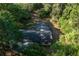 Overhead perspective of the house roof surrounded by lush greenery, emphasizing a private, wooded setting at 16571 Se 95Th Street Rd, Ocklawaha, FL 32179