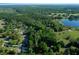 Aerial view showcasing a wooded property with a lake nearby, highlighting its natural setting at 16571 Se 95Th Street Rd, Ocklawaha, FL 32179