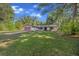 Cozy home with lush green lawn surrounded by mature trees providing shade, complete with attached garage at 16571 Se 95Th Street Rd, Ocklawaha, FL 32179