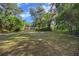 A lush front yard enhances the curb appeal of this charming home with a red garage door at 16571 Se 95Th Street Rd, Ocklawaha, FL 32179