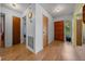 Bright hallway featuring hardwood floors, neutral walls, and a view of the front door and other rooms at 16571 Se 95Th Street Rd, Ocklawaha, FL 32179