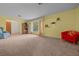 Spacious living area featuring neutral carpet, bright yellow walls, and large window with views to the outside at 16571 Se 95Th Street Rd, Ocklawaha, FL 32179