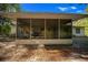 View of the screened-in porch with furniture overlooking a yard covered in leaves at 16571 Se 95Th Street Rd, Ocklawaha, FL 32179