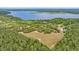 Breathtaking aerial view of lush property with lake access and a large field surrounded by mature trees at 16891 Ne 243Rd Place Rd, Fort Mc Coy, FL 32134