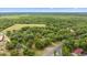 Expansive aerial view of a sprawling property featuring lush greenery, open fields, and a peaceful, rural setting at 16891 Ne 243Rd Place Rd, Fort Mc Coy, FL 32134