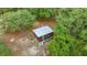 Aerial view of a storage shed with a metal roof surrounded by lush greenery, providing secure outdoor storage at 16891 Ne 243Rd Place Rd, Fort Mc Coy, FL 32134
