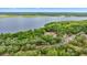 Scenic aerial view of a home nestled among lush greenery near a tranquil lake with a visible shoreline at 16891 Ne 243Rd Place Rd, Fort Mc Coy, FL 32134