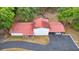 Aerial view of back exterior of the house with a red roof, carport, and spacious backyard at 16891 Ne 243Rd Place Rd, Fort Mc Coy, FL 32134