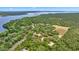 Expansive lot features wooded areas, a lake, and a house, all visible from above at 16891 Ne 243Rd Place Rd, Fort Mc Coy, FL 32134