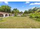 Expansive lawn view of the home, with symmetrical design, mature trees, and bright, open skies at 16891 Ne 243Rd Place Rd, Fort Mc Coy, FL 32134