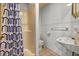 Tiled bathroom featuring a shower, toilet, and sink, designed for functionality and cleanliness at 16891 Ne 243Rd Place Rd, Fort Mc Coy, FL 32134