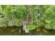 Rustic wooden dock leading to serene lake, featuring a staircase surrounded by dense trees and Spanish moss at 16891 Ne 243Rd Place Rd, Fort Mc Coy, FL 32134