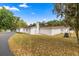 Expansive single-story home featuring white stucco and a red tile roof, surrounded by lush landscaping at 16891 Ne 243Rd Place Rd, Fort Mc Coy, FL 32134