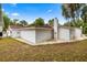 Rear exterior view of a pristine white home with a chimney, offering a glimpse into its simple, elegant design at 16891 Ne 243Rd Place Rd, Fort Mc Coy, FL 32134