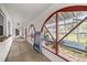 Hallway with arch windows offering outdoor views, artful décor, and access to a bright greenhouse at 16891 Ne 243Rd Place Rd, Fort Mc Coy, FL 32134