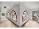 Bright hallway with arched windows, red trim, and multiple entry points into adjoining spaces at 16891 Ne 243Rd Place Rd, Fort Mc Coy, FL 32134