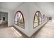 Corner view of a hallway featuring arch windows with red trim and plenty of natural light at 16891 Ne 243Rd Place Rd, Fort Mc Coy, FL 32134