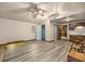 Bright and airy living room with wood-look floors, ceiling fan, and access to a kitchenette and bathroom at 16891 Ne 243Rd Place Rd, Fort Mc Coy, FL 32134