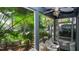 Relaxing screened-in patio with a view of tropical landscaping and seating area at 20800 River Dr # A11, Dunnellon, FL 34431